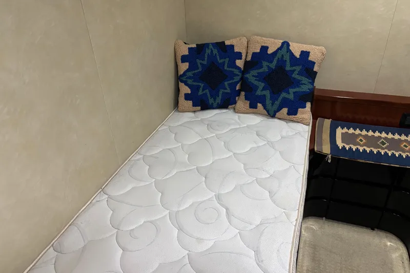 Slide: The Image of Small bed with patterned cushions in a 1986 Maiora Phantom yacht cabin. - 25