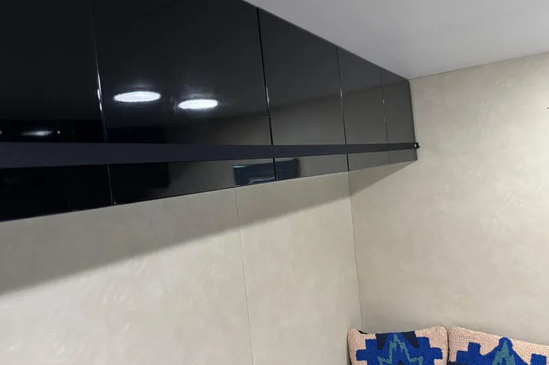 Slide: The Image of Sleek black cabinets in a 1986 Maiora Phantom interior, with modern lighting and textured cushions. - 27