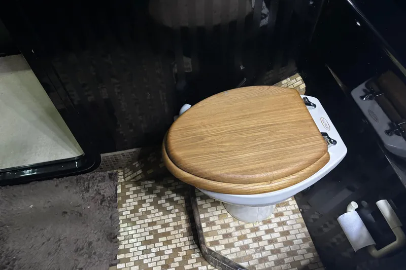 Slide: The Image of Wooden toilet seat in a 1986 Maiora Phantom yacht bathroom with mosaic tile flooring. - 31