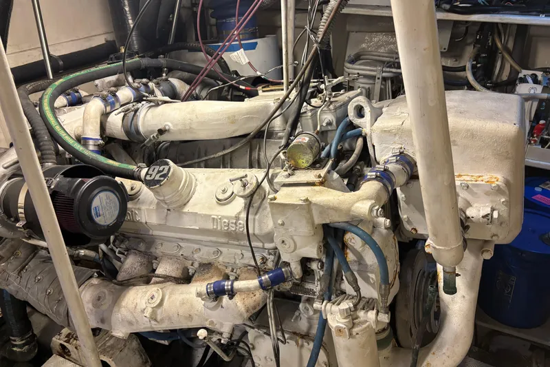 Slide: The Image of Engine room of a 1986 Maiora Phantom yacht, showcasing a diesel engine with various hoses and components. - 35