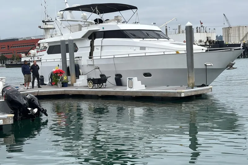 Slide: The Image of 1986 Maiora Phantom yacht docked at marina with people nearby, overcast sky. - 5
