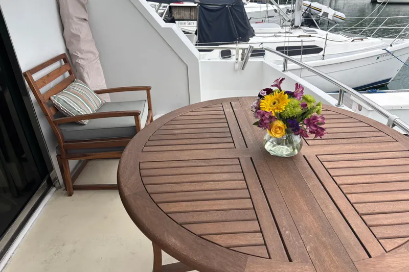 Slide: The Image of Wooden deck with flowers on a Maiora Phantom 1986 yacht, overlooking marina. - 8