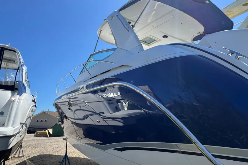 Slide: The Image of 2006 Formula 40 Performance Cruiser with sleek blue hull, docked under clear sky. - 3