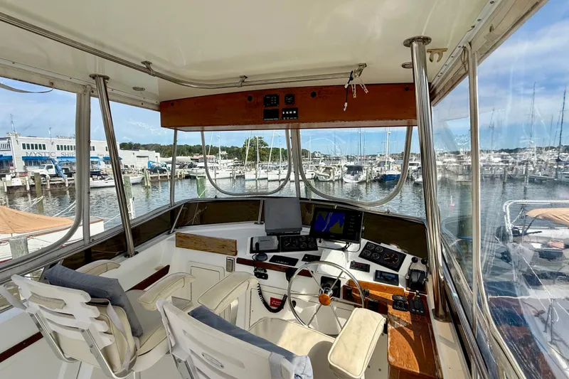 Slide: The Image of 2001 Sabre Sabreline 34 boat cockpit with marina view, featuring navigation equipment and seating. - 21