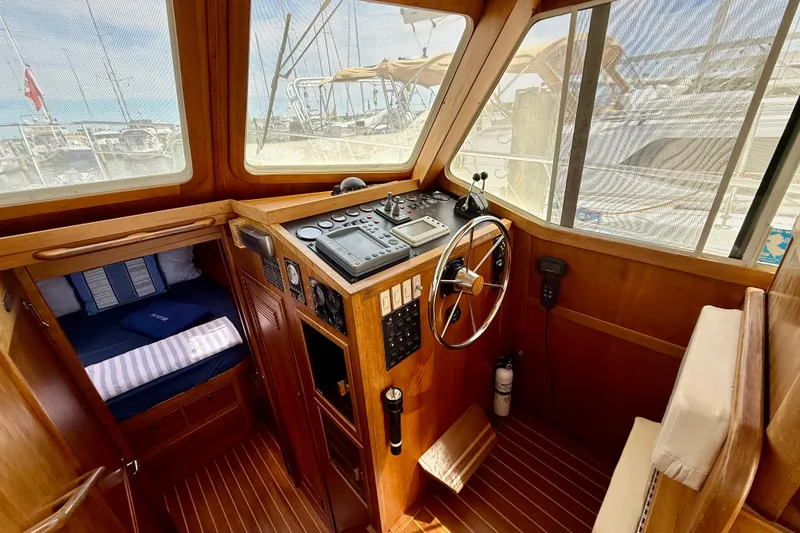 Slide: The Image of 2001 Sabre Sabreline 34 boat interior with wooden helm, steering wheel, and navigation controls. - 34