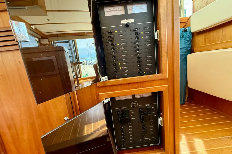 Slide: The Image of Electrical control panel inside 2001 Sabre Sabreline 34 boat, featuring wooden interior. - 36