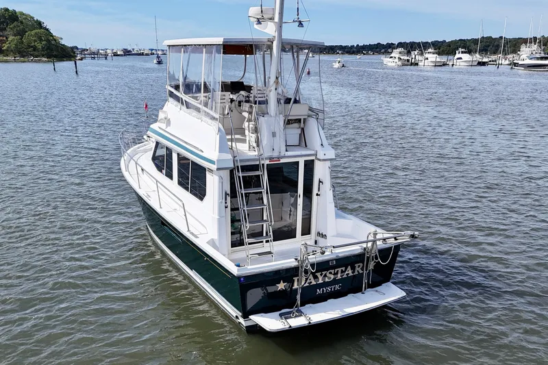 Slide: The Image of 2001 Sabre Sabreline 34 yacht on calm waters, featuring a spacious deck and elegant design. - 4