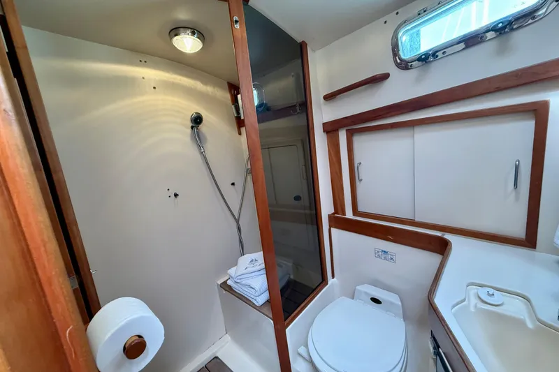 Slide: The Image of 2001 Sabre Sabreline 34 yacht bathroom with shower, toilet, and wooden cabinetry. - 40