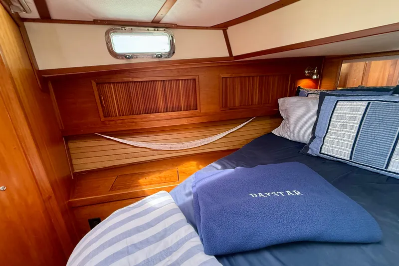 Slide: The Image of Cozy cabin interior of 2001 Sabre Sabreline 34 with wooden accents and nautical bedding. - 42