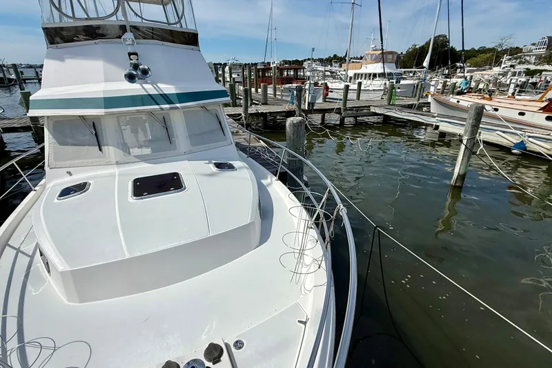 Slide: The Image of 2001 Sabreline 34 boat docked at marina, surrounded by water and other vessels. - 9
