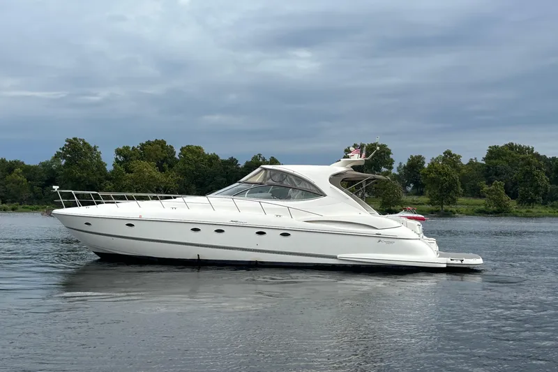 Slide: The Image of 2006 Cruisers Yachts 560 Express on calm water, surrounded by lush greenery. - 3
