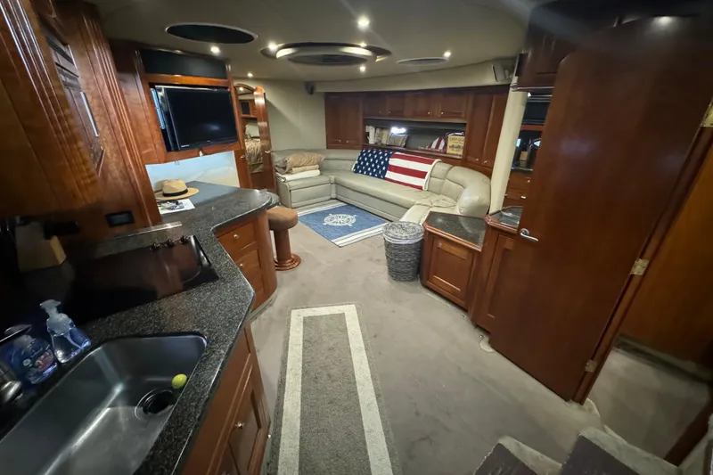 Slide: The Image of Luxurious 2006 Cruisers Yachts 560 Express interior with elegant wood finishes and cozy seating. - 13