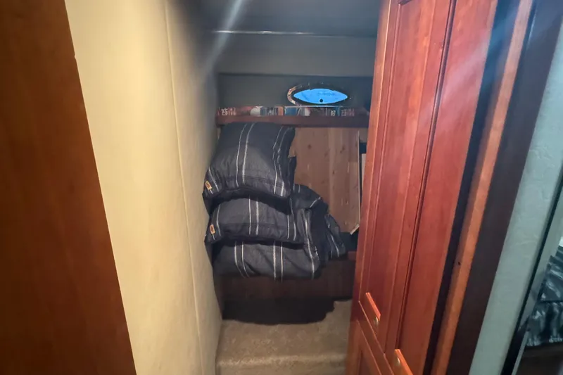 Slide: The Image of 2006 Cruisers Yachts 560 Express cabin interior with bed and wooden cabinetry. - 18