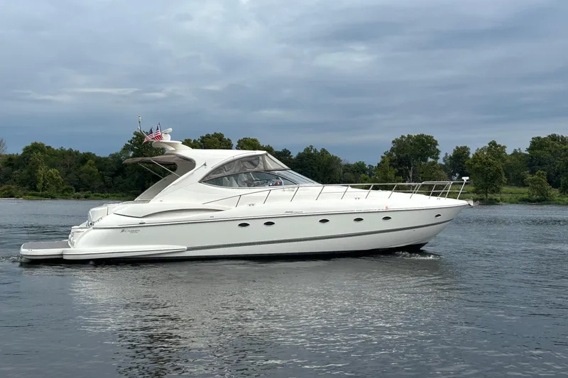 Slide: The Image of 2006 Cruisers Yachts 560 Express on a serene river with lush greenery. - 2