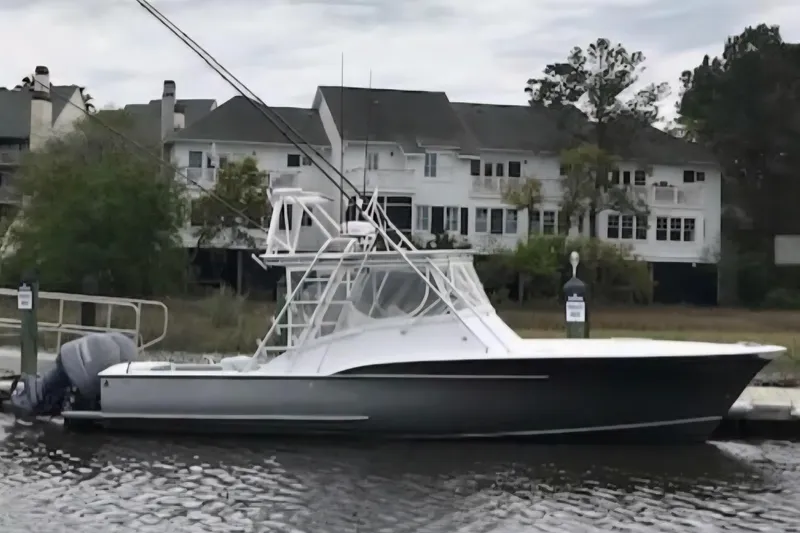 Slide: The Image of 2003 Shearline 30 Express boat docked by waterfront homes. - 1