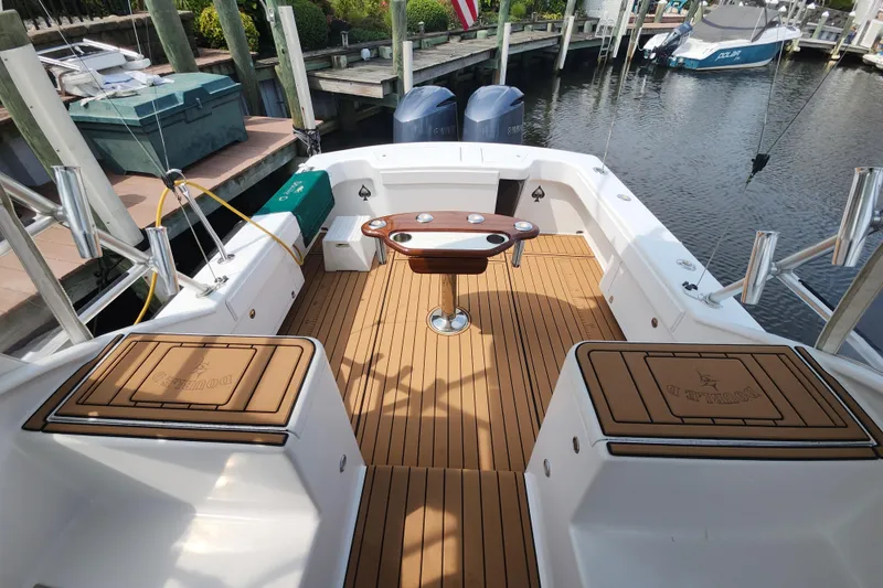Slide: The Image of 2003 Shearline 30 Express boat deck with teak flooring and fishing rod holders. - 11