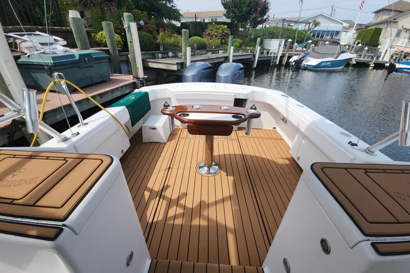 Slide: The Image of 2003 Shearline 30 Express boat with teak deck and fishing setup in a marina. - 12