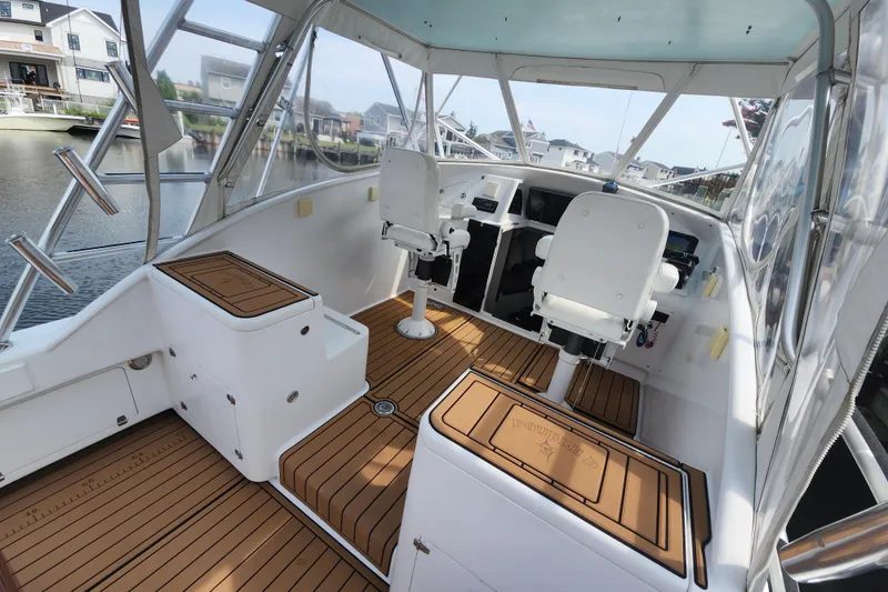 Slide: The Image of 2003 Shearline 30 Express boat interior with helm chairs and wooden deck. - 13