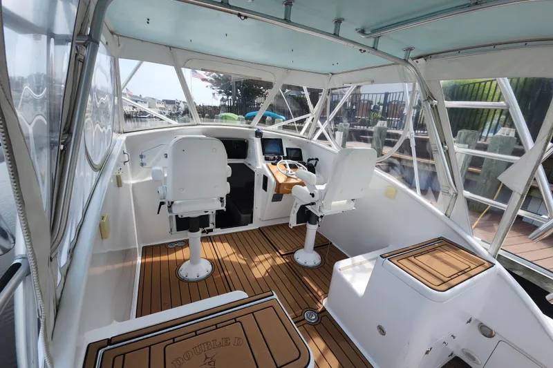 Slide: The Image of 2003 Shearline 30 Express boat interior with helm, seating, and wooden flooring. - 15