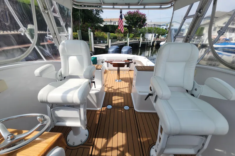 Slide: The Image of 2003 Shearline 30 Express boat interior with white seats and wooden flooring. - 16