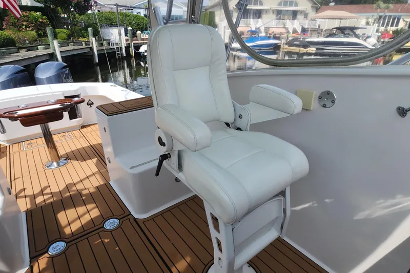 Slide: The Image of 2003 Shearline 30 Express boat interior with white captain's chair and wooden deck. - 17