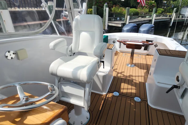 Slide: The Image of 2003 Shearline 30 Express boat interior with white captain's chair and wooden deck. - 18