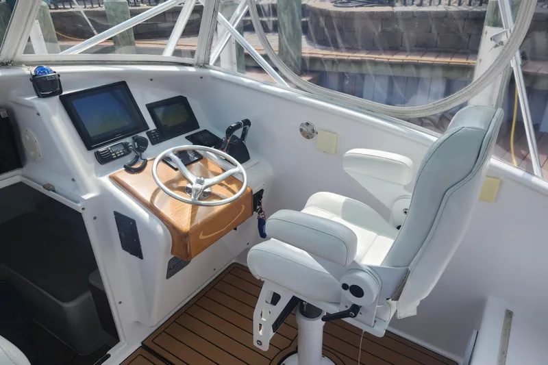 Slide: The Image of 2003 Shearline 30 Express boat helm with steering wheel and navigation screens. - 19