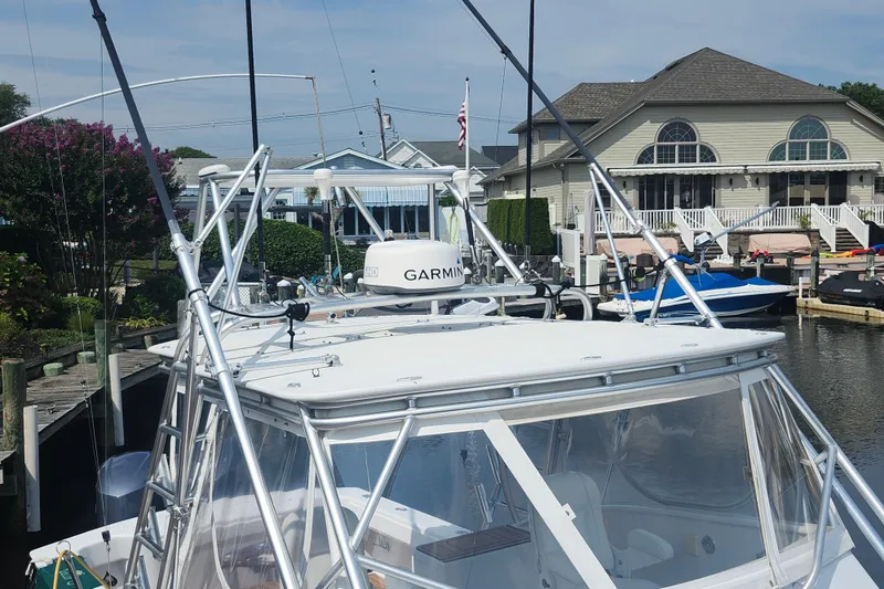 Slide: The Image of 2003 Shearline 30 Express boat docked near waterfront homes, featuring Garmin equipment. - 26
