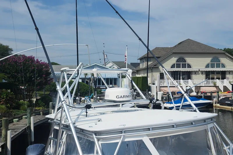 Slide: The Image of 2003 Shearline 30 Express boat docked near waterfront homes. - 27