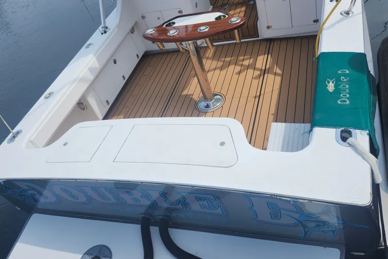 Slide: The Image of 2003 Shearline 30 Express boat deck with wooden flooring and fishing rod holders. - 34
