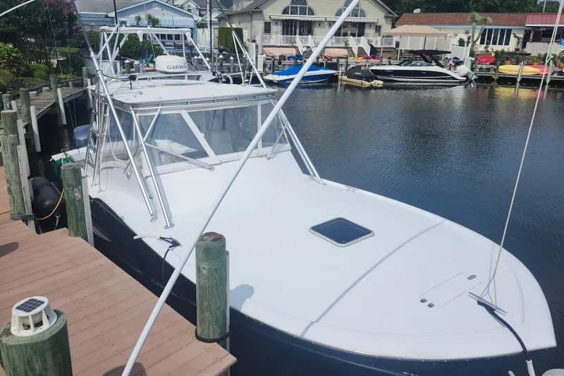 Slide: The Image of 2003 Shearline 30 Express boat docked in a marina, surrounded by other boats. - 4