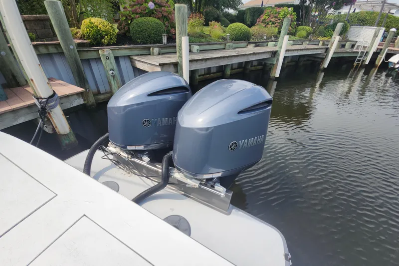 Slide: The Image of Twin Yamaha outboard engines on a 2003 Shearline 30 Express boat docked by a wooden pier. - 46