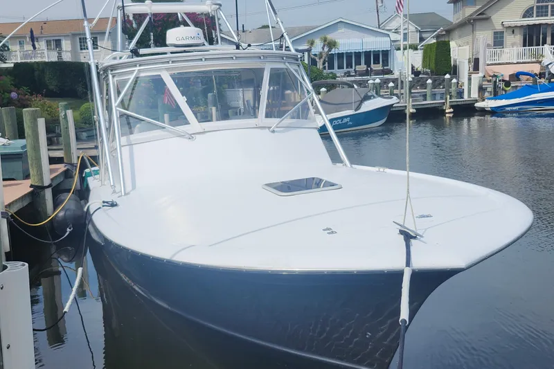 Slide: The Image of 2003 Shearline 30 Express boat docked in a marina, front view. - 5