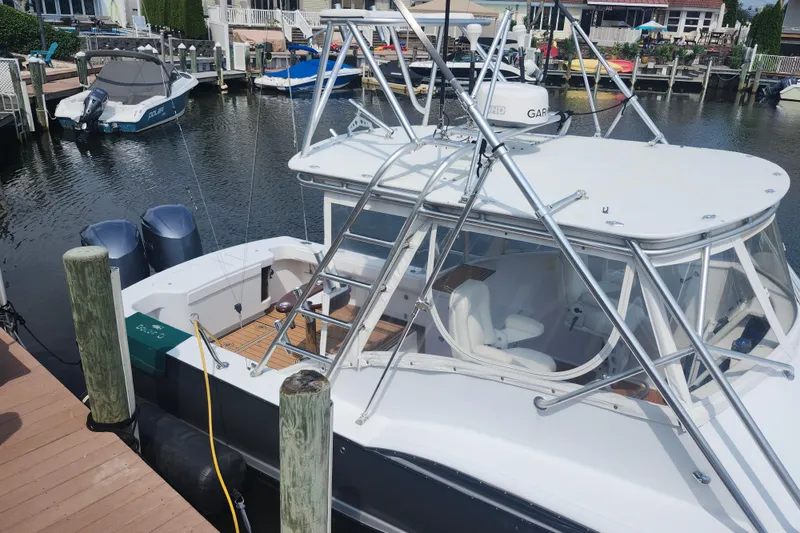 Slide: The Image of 2003 Shearline 30 Express boat docked in a marina, featuring dual outboard motors. - 7