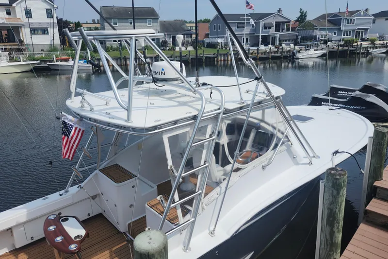 Slide: The Image of 2003 Shearline 30 Express boat docked in a marina, featuring a sleek design and American flag. - 8