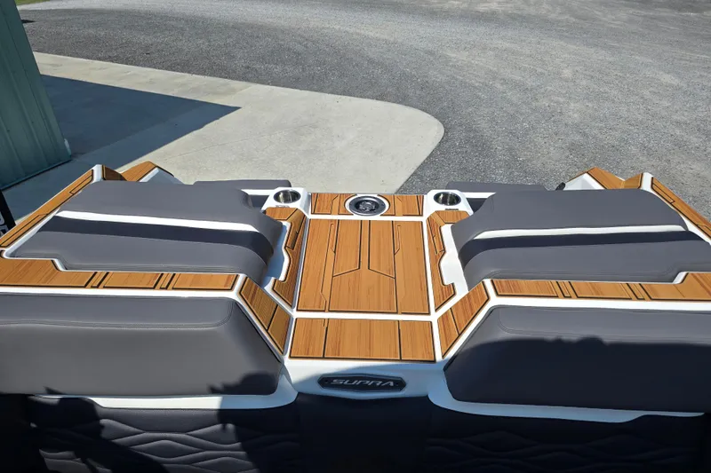 Slide: The Image of 2026 Supra SA boat with sleek teak deck and cushioned seating. - 16
