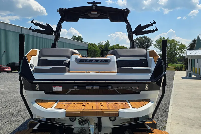 Slide: The Image of 2026 Supra SA boat with sleek design, featuring SwellSurf technology, parked outdoors. - 20