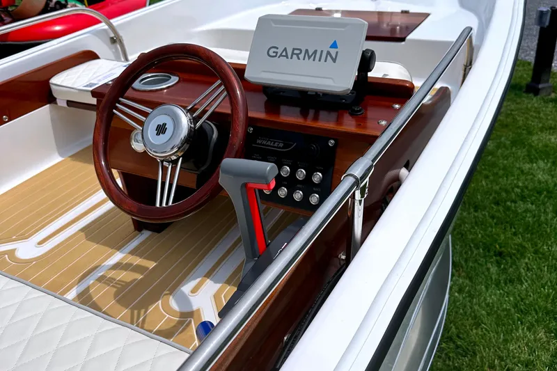 Slide: The Image of 1981 Boston Whaler 13 Super Sport boat interior with Garmin navigation system and wooden steering wheel. - 13