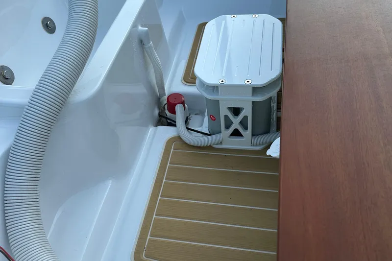 Slide: The Image of 1981 Boston Whaler 13 Super Sport interior with hoses and storage compartment. - 16
