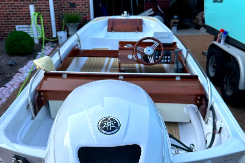 Slide: The Image of 1981 Boston Whaler 13 Super Sport boat with Yamaha engine, parked near a brick wall. - 18