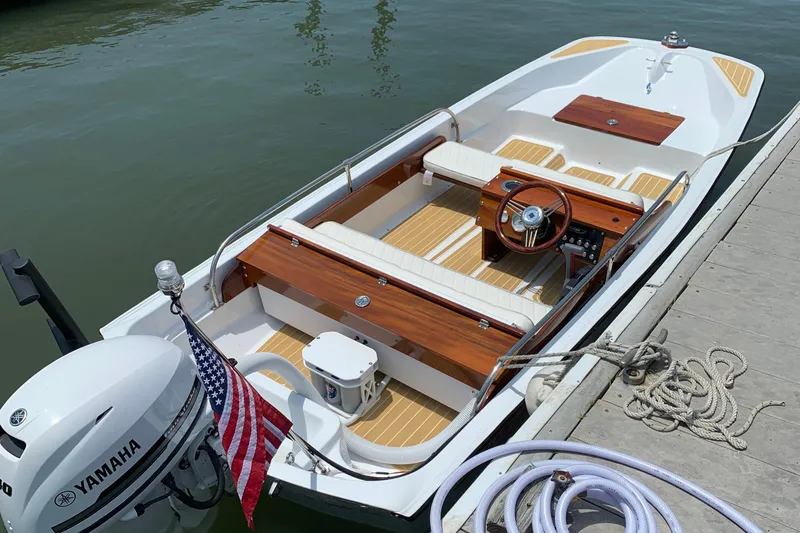 Slide: The Image of 1981 Boston Whaler 13 Super Sport boat docked, featuring Yamaha outboard motor and American flag. - 2