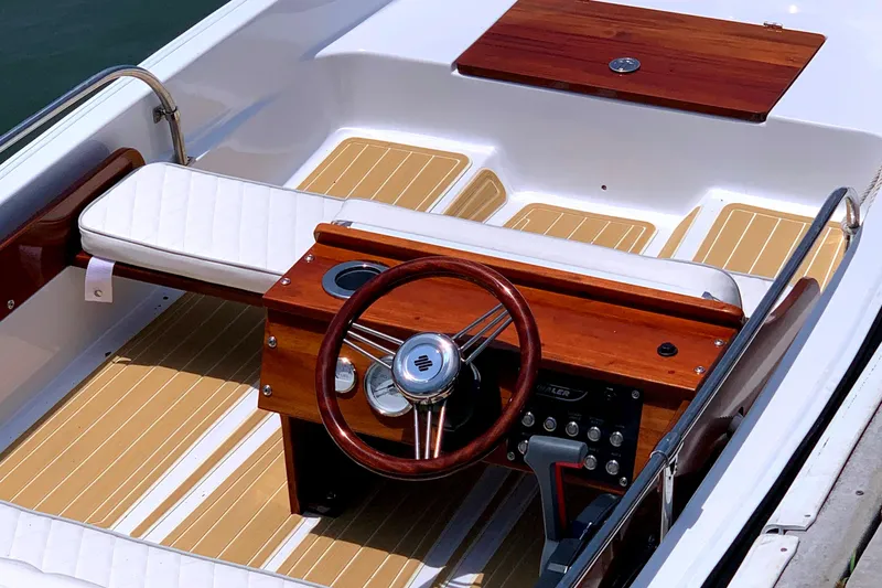Slide: The Image of 1981 Boston Whaler 13 Super Sport boat interior with wooden steering wheel and seating. - 4