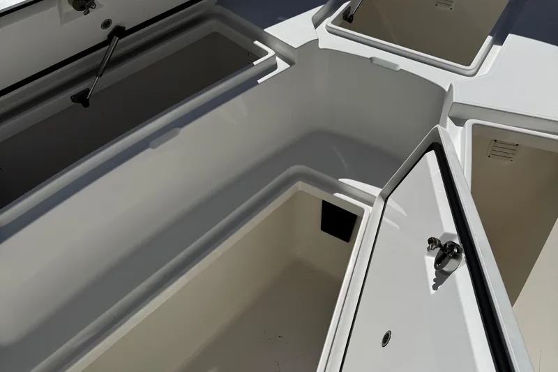 Slide: The Image of 2015 Regulator 28 Forward Seating boat storage compartments open, showcasing interior space. - 18