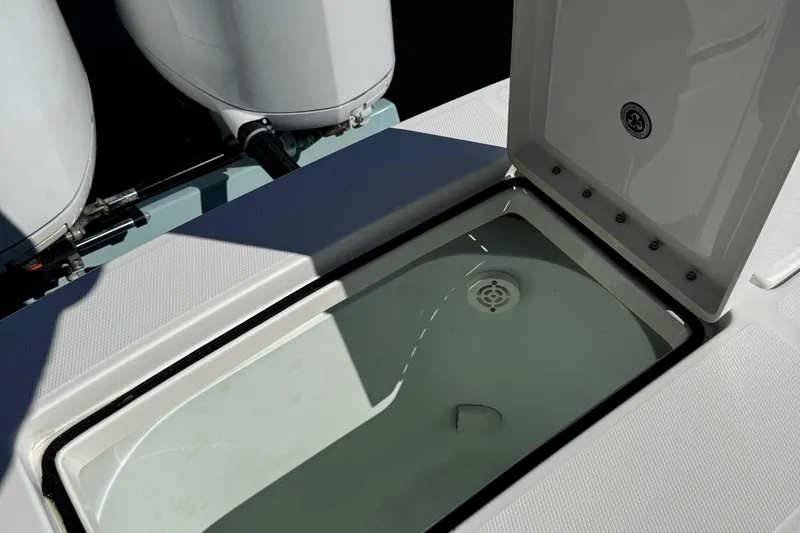 Slide: The Image of Open storage compartment on 2015 Regulator 28 Forward Seating boat, with visible engine parts. - 24
