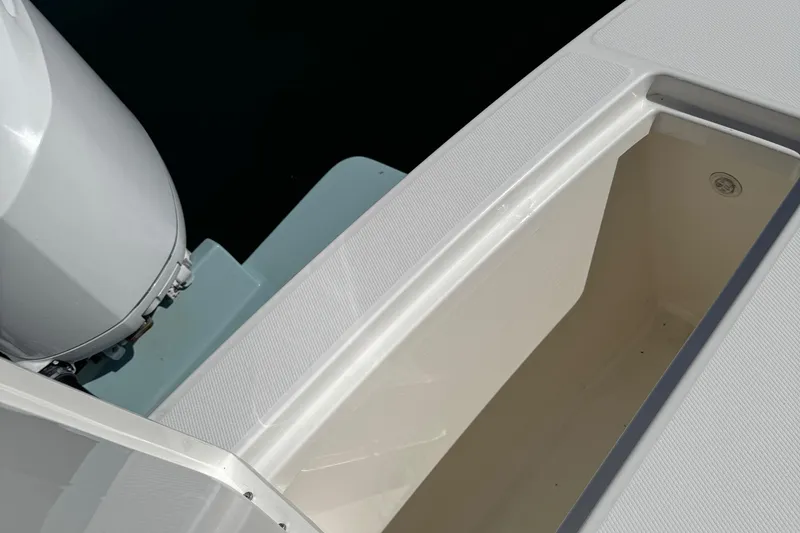 Slide: The Image of 2015 Regulator 28 Forward Seating boat with open storage compartment and visible engine. - 25