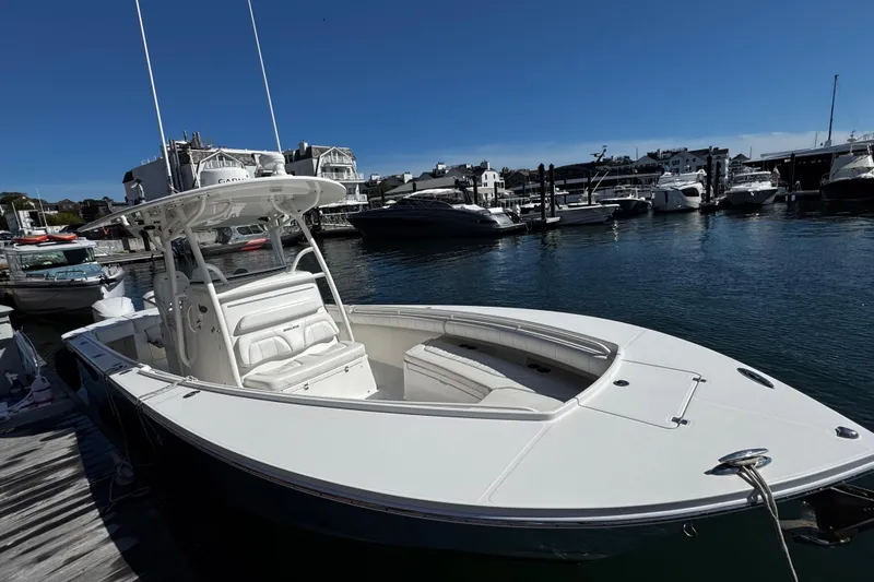 Slide: The Image of 2015 Regulator 28 Forward Seating boat docked at a marina under clear blue skies. - 3