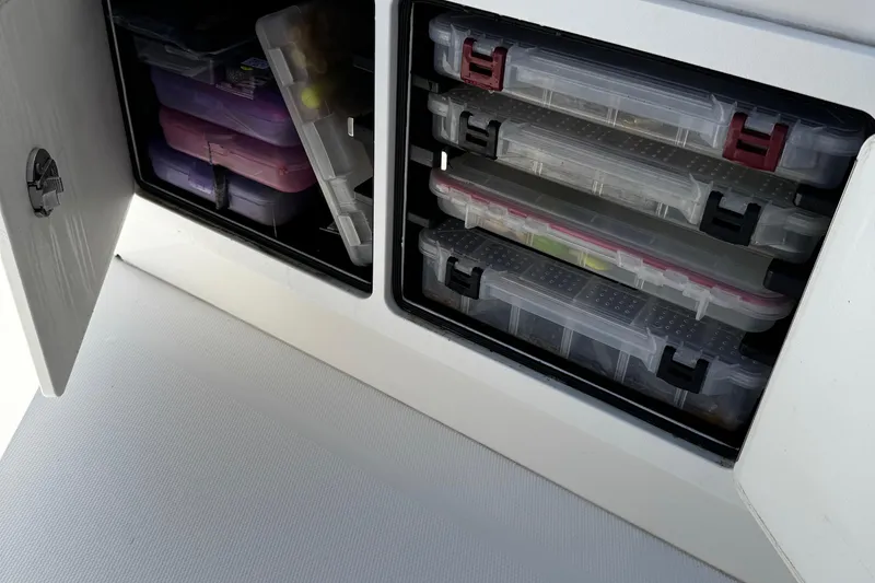 Slide: The Image of Storage compartments with tackle boxes on a 2015 Regulator 28 Forward Seating boat. - 32