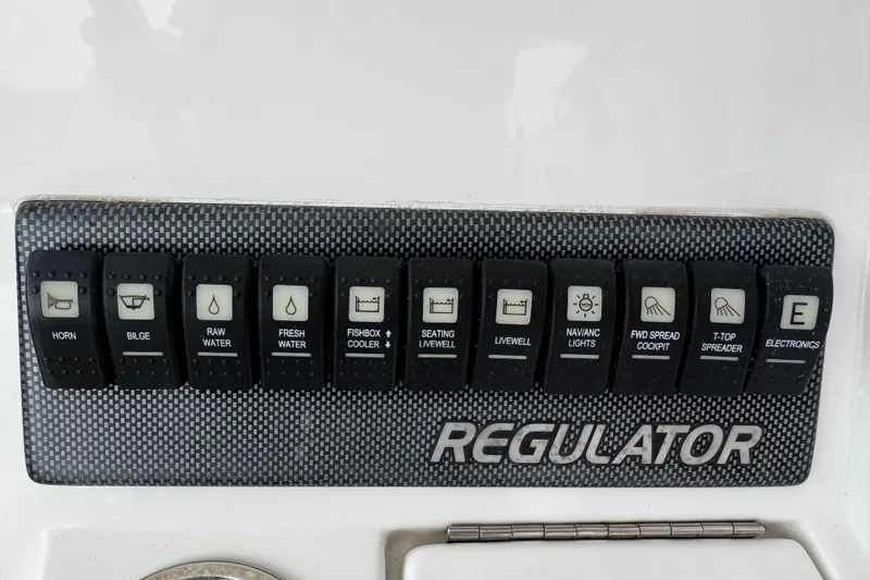 Slide: The Image of Control panel of a 2015 Regulator 28 Forward Seating boat with labeled switches. - 36