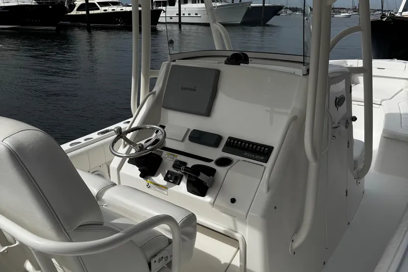Slide: The Image of 2015 Regulator 28 Forward Seating boat helm with Garmin navigation system, docked in marina. - 5