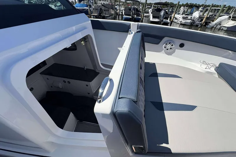 Slide: The Image of 2026 Monterey 25 Elite boat interior with seating and storage, docked at a marina. - 10